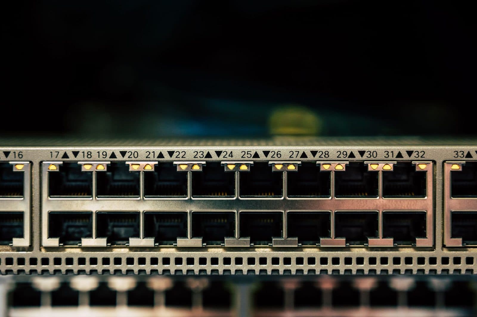 Primer plano de los puertos RJ45 numerados de un conmutador de red con los pilotos encendidos