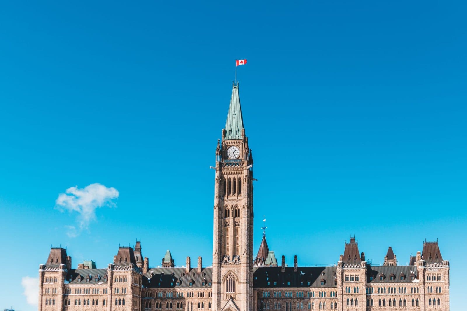 Torre della Pace del Parlamento canadese a Ottawa, bandiera del Canada in cima, sotto un cielo azzurro