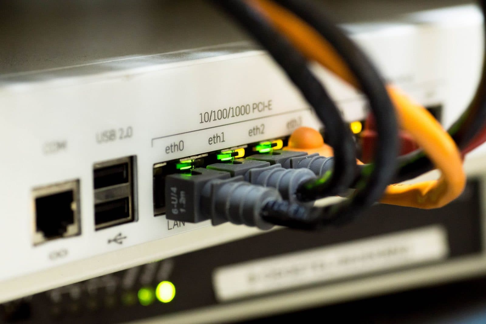 Gros plan sur les ports Ethernet et USB d'un routeur avec câbles RJ45 branchés et voyants verts allumés