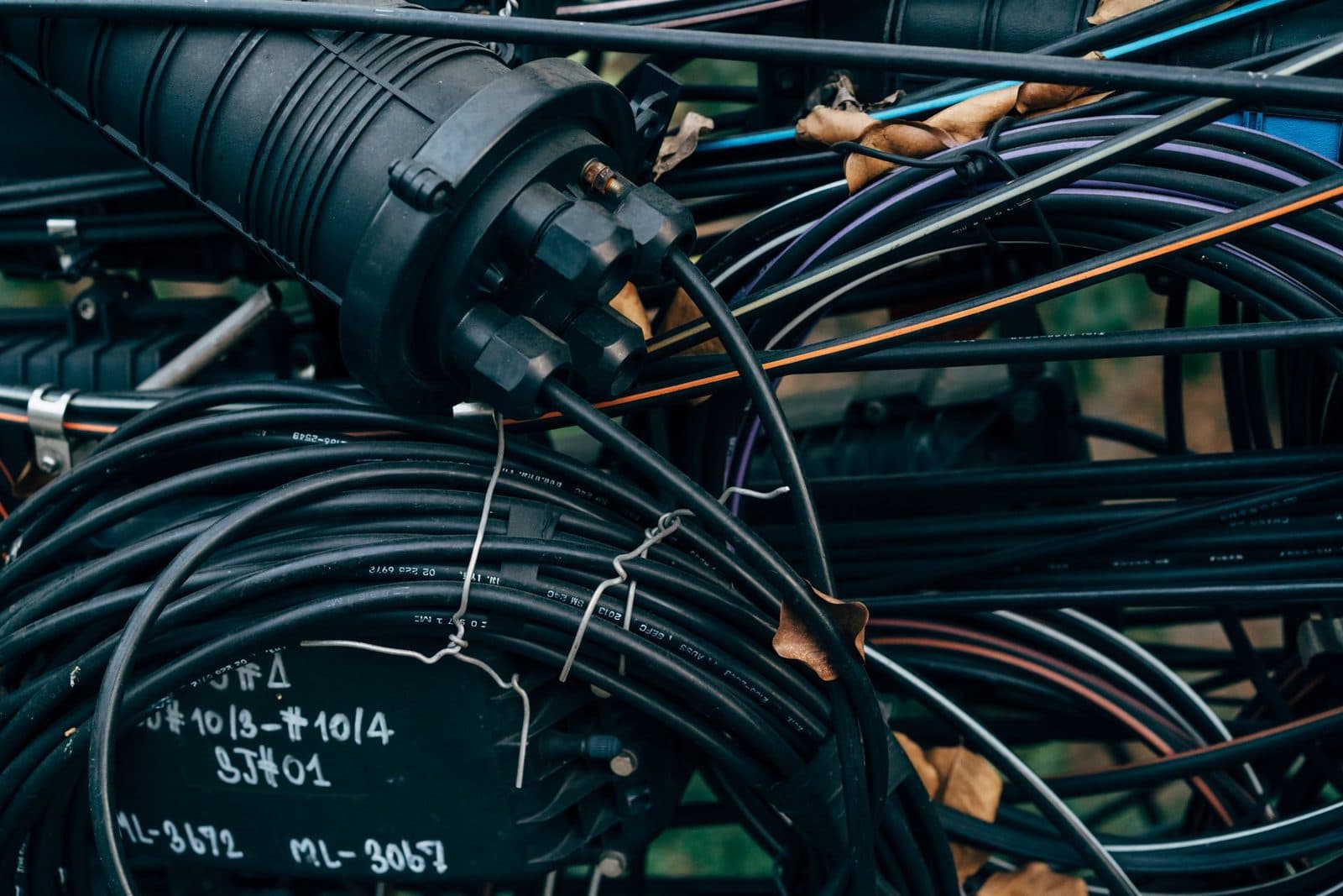 Anschlusskasten und aufgewickelte Telekommunikationskabelbündel an einem Masten, handschriftlich beschriftet